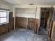Damaged living room with exposed walls, open closet, and doorway at 12812 1St Isle, Hudson, FL 34667