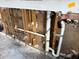 Damaged plumbing with exposed pipes and wall studs showing missing drywall and water damage at 12812 1St Isle, Hudson, FL 34667