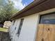 Exterior view of a single-story home showing the yard and boarded up windows at 12812 1St Isle, Hudson, FL 34667