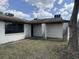 Exterior view of a single-story home showing the yard and covered entryway at 12812 1St Isle, Hudson, FL 34667
