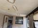 Damaged ceiling with water stains view of open doorway to kitchen and two windows at 12812 1St Isle, Hudson, FL 34667