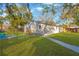 Spacious backyard showcasing a charming home, lush lawn, and a welcoming wooden deck at 12918 Cambridge Ave, Tampa, FL 33624