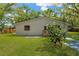 Exterior view of the home's backyard featuring manicured lawn and mature trees at 12918 Cambridge Ave, Tampa, FL 33624