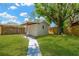 Spacious backyard featuring a storage shed, lush green lawn, and privacy fence at 12918 Cambridge Ave, Tampa, FL 33624