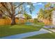 Expansive backyard with lush green grass, a large shade tree, and a seating area, perfect for outdoor enjoyment at 12918 Cambridge Ave, Tampa, FL 33624
