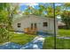 Home's backyard featuring a small wooden deck and lush green lawn at 12918 Cambridge Ave, Tampa, FL 33624