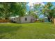 Expansive backyard featuring a well-maintained lawn, patio, and storage shed at 12918 Cambridge Ave, Tampa, FL 33624