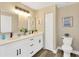 Bright bathroom featuring double vanity with modern fixtures, and a separate toilet room at 12918 Cambridge Ave, Tampa, FL 33624