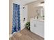 Bathroom features tub with blue patterned shower curtain and vanity with undermount sink at 12918 Cambridge Ave, Tampa, FL 33624