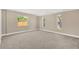 Neutral bedroom with plush carpeting and abundant natural light from multiple windows at 12918 Cambridge Ave, Tampa, FL 33624