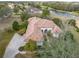 An aerial view of this gorgeous home featuring a beautiful tile roof, landscaping, and access to a community lake at 13315 Carnoustie Cir, Dade City, FL 33525