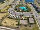 Aerial view of community pool, clubhouse, tennis court and playground in a well-maintained neighborhood with lush landscaping at 3091 King Fern Dr, Wimauma, FL 33598