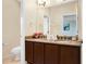 Bright bathroom featuring double sinks, granite countertops, and dark wood cabinets at 310 Summer Clouds Pl, Brandon, FL 33511