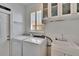 Well-lit laundry room with modern washer, dryer, sink, and storage cabinets, offering convenience and functionality at 3110 Bent Creek Dr, Valrico, FL 33596