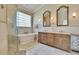 Elegantly designed main bathroom with a soaking tub, frameless shower, and double vanity at 3110 Bent Creek Dr, Valrico, FL 33596