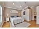 Spacious main bedroom with an arched window, neutral tones, and hardwood floors at 3110 Bent Creek Dr, Valrico, FL 33596