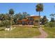 Backyard featuring a walkway to the home, a manicured lawn, and palm trees at 316 Shore E Dr, Oldsmar, FL 34677