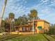 Spacious home with an orange exterior, red roof, and well-manicured front yard at 316 Shore E Dr, Oldsmar, FL 34677