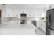 Modern kitchen with white cabinets, marble countertops, and stainless steel appliances at 316 Shore E Dr, Oldsmar, FL 34677