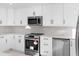 Updated kitchen with stainless steel appliances, white cabinetry, and stylish backsplash at 316 Shore E Dr, Oldsmar, FL 34677