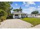 Charming gray home featuring a well-maintained lawn and a fresh gravel driveway at 6142 4Th S Ave, St Petersburg, FL 33707