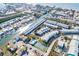 Stunning aerial view of a waterfront condo community with boat docks, lush landscaping, and community pool and tennis courts at 657 Garland Cir, Indian Rocks Beach, FL 33785