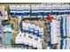 Bright aerial view of community with a tennis court, swimming pool, and rows of townhomes at 657 Garland Cir, Indian Rocks Beach, FL 33785