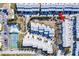 Bright aerial view of community with a tennis court, swimming pool, and rows of townhomes at 657 Garland Cir, Indian Rocks Beach, FL 33785