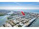 Spectacular aerial view of waterfront condos with boat docks, community amenities, and scenic waterways under a clear sky at 657 Garland Cir, Indian Rocks Beach, FL 33785