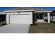 Charming home featuring an attached two-car garage, well-kept lawn, and modern architectural details at 695 Allora Ave, Nokomis, FL 34275