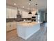 Bright kitchen features white cabinets, stainless appliances, a large island, pendant lights, and wood-look flooring at 695 Allora Ave, Nokomis, FL 34275