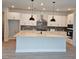 Modern kitchen with white cabinets, gray backsplash, stainless hood, and a large island with pendant lighting at 695 Allora Ave, Nokomis, FL 34275