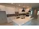 Bright kitchen featuring white cabinets, an island with quartz countertop, and modern black pendant lights at 695 Allora Ave, Nokomis, FL 34275