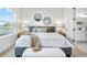 This bedroom features two decorative circular mirrors, large bed, an attached bathroom, and an amazing lakeside view at 11341 Hardwood Hammock Ln, Riverview, FL 33569