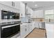 Modern kitchen features stainless steel appliances, sleek white cabinets, and stylish backsplash at 11341 Hardwood Hammock Ln, Riverview, FL 33569