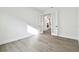 Minimalist office space with wood floors, white walls, and glass doors leading to the kitchen at 11341 Hardwood Hammock Ln, Riverview, FL 33569