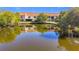 Exterior view of home overlooking a lake with green trees and reflection at 13600 Egret Blvd # 204K, Clearwater, FL 33762