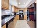 Kitchen featuring ample wood cabinetry, black appliances, and black granite countertops at 13600 Egret Blvd # 204K, Clearwater, FL 33762