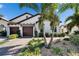 Beautiful home with a paver driveway, two car garage, and lush tropical landscaping at 17014 Clear Cork Dr, Wimauma, FL 33598