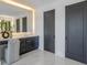 Bathroom with a vanity and illuminated mirror, complemented by clean lines and elegant marble floors and wood cabinets at 2081 Michigan Ne Ave, St Petersburg, FL 33703