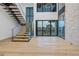 Bright interior showcases a modern staircase, hardwood floors, and a wall of windows at 2081 Michigan Ne Ave, St Petersburg, FL 33703