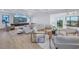 Open-concept living room with modern furnishings, large TV, and elegant staircase in background at 2081 Michigan Ne Ave, St Petersburg, FL 33703