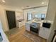Modern kitchen with stainless steel appliances, white cabinets, and view of the living room at 2427 10Th S Ave, St Petersburg, FL 33712
