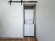 Convenient laundry area with stacked washer and dryer, enclosed with a sliding barn door at 2427 10Th S Ave, St Petersburg, FL 33712