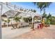 Outdoor patio with pergola, dining table and chairs, bar seating, and vibrant landscaping at 263 42Nd Ne Ave, St Petersburg, FL 33703