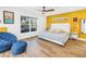 Bright bedroom featuring modern furnishings, hardwood floors, and a yellow accent wall at 263 42Nd Ne Ave, St Petersburg, FL 33703