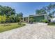 A beautiful single-Gathering home boasting lush landscaping and a stylish brick paver driveway leading to a bright yellow front door at 263 42Nd Ne Ave, St Petersburg, FL 33703