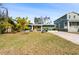 Beautiful green single-Gathering home featuring a well-manicured lawn, tropical landscaping, and a yellow door with charming chairs at 263 42Nd Ne Ave, St Petersburg, FL 33703