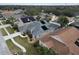 Aerial view of the home, showing its roof-mounted solar panels, in a neighborhood with screened in pools at 5206 Whispering Leaf Trl, Valrico, FL 33596