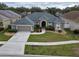 Charming single-story home with a well-manicured lawn, mature landscaping, and a two-car garage at 5206 Whispering Leaf Trl, Valrico, FL 33596